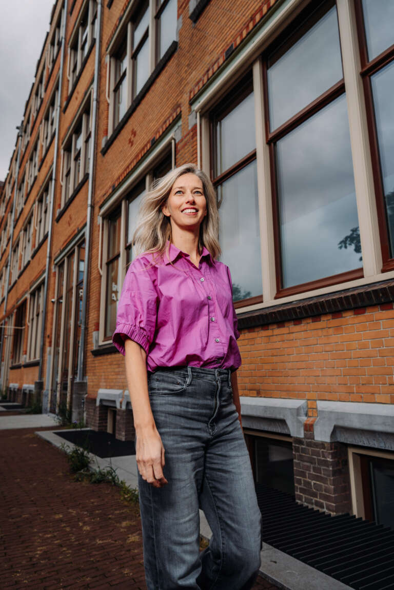 A woman walking confidently along a brick-lined city street.