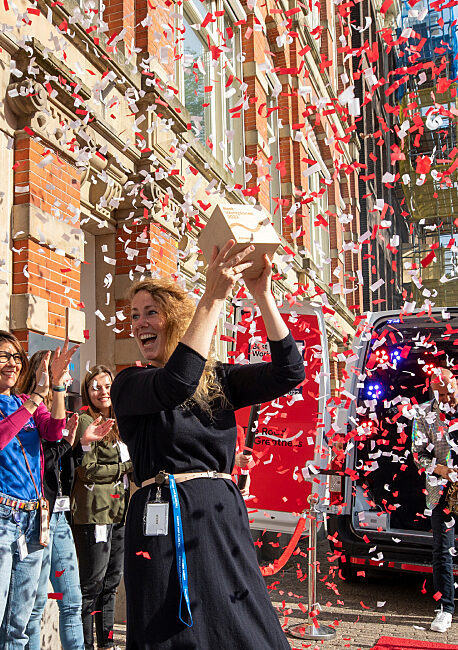 Celebration in front of the offices with confetti and enthusiastic colleagues