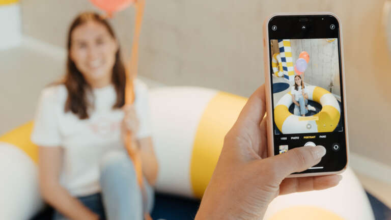 Young woman photographed with colorful balloons during a joyful event