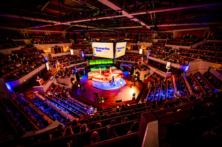 Corporate convention in an immersive room, with central stage and involved audience